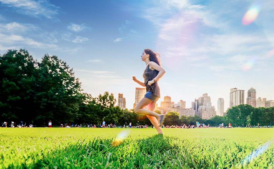 A woman running in a park that symbolizes sustainability, surrounded by office buildings that symbolize business