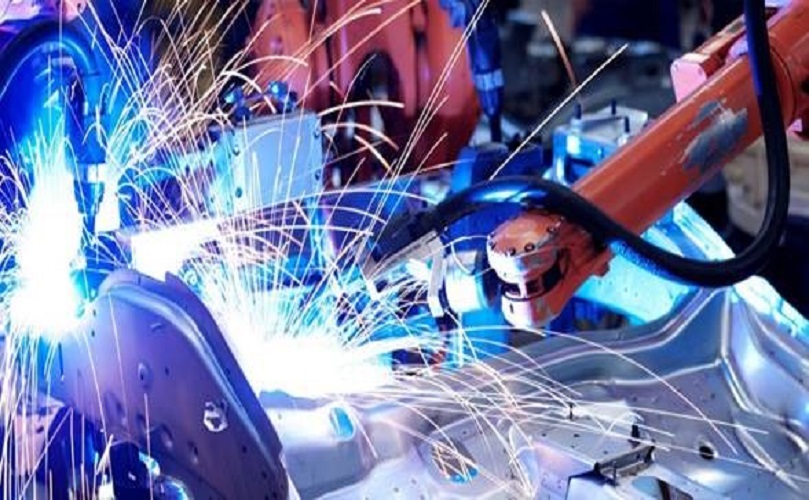 工場で金属製品がロボットによって加工される