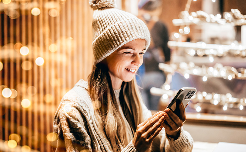 A young woman looking at her smartphone while shopping