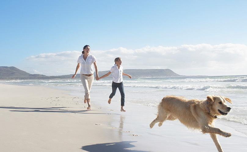 Mother and daughter running on beach