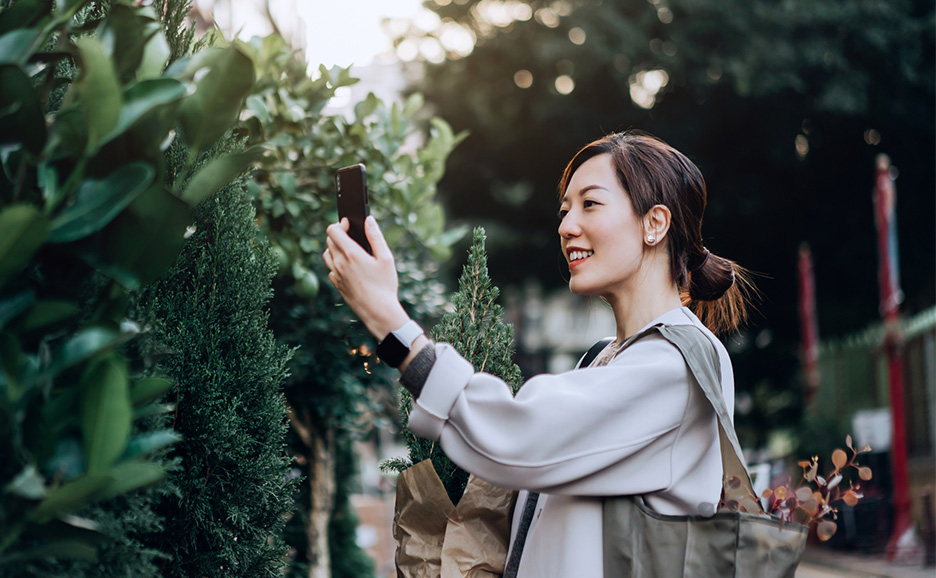 A woman taking pictures of plants at a flower market