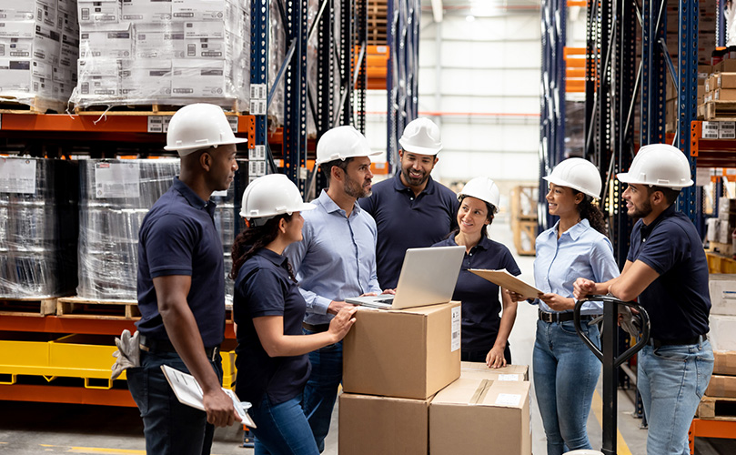 Group of employees speaking at a distribution warehouse