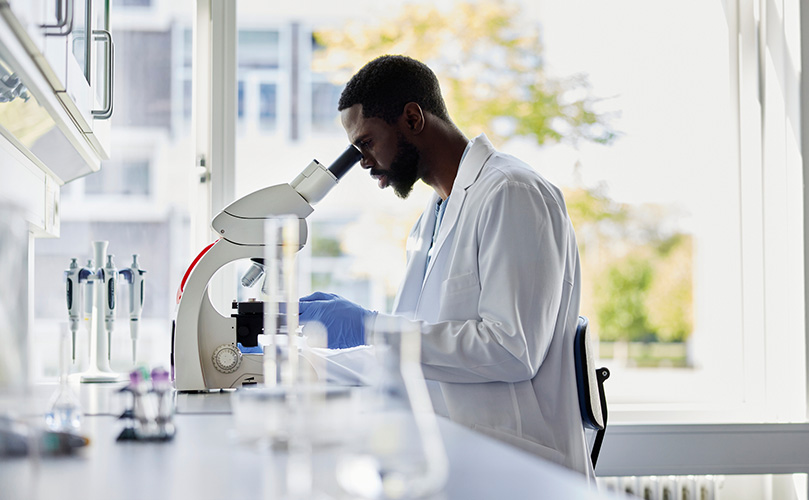 顕微鏡を調べる男性化学者