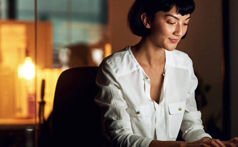 Shot of a young woman using a digital device at night