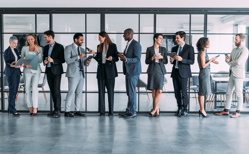 Ten people at the office in a queue talking with each other